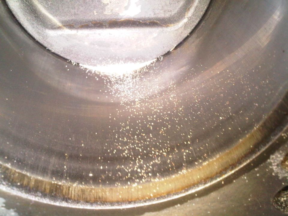 Close-up of curved machined metal surface with metallic flakes and wear rings