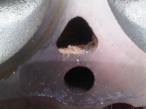 1985 Ford Bronco - Close-up view of an engine component two distinct openings.