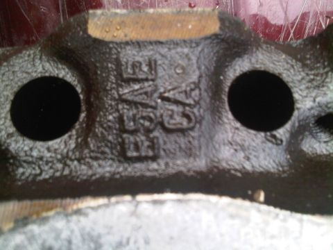 1985 Ford Bronco - A close-up view of a cast metal component shows raised lettering, likely a part number or manufacturer code.