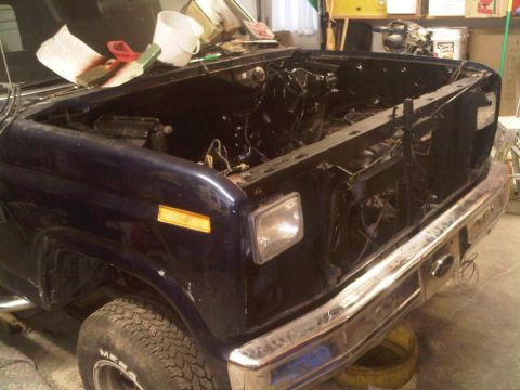 1985 Ford Bronco - This 1985 Ford Bronco is shown with its hood open and engine removed, indicating it is undergoing maintenance or restoration.