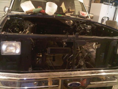 1985 Ford Bronco - Engine bay of a 1985 Ford Bronco undergoing repairs, with the engine out.