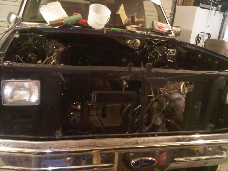 1985 Ford Bronco engine bay with engine removed for repair, showing wiring and frame