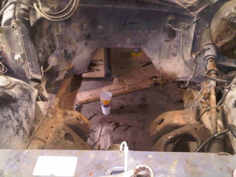 1985 Ford Bronco - The engine bay of a 1985 Ford Bronco shows significant rust and frame damage, indicating a need for extensive restoration.