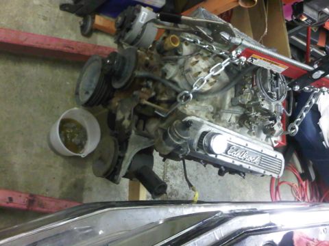 1985 Ford Bronco - An engine with Edelbrock valve covers is being worked on, suspended by a chain hoist.