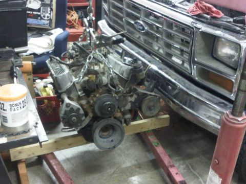 1985 Ford Bronco - Engine removal in progress from a Ford truck, identifiable by its grille design from the early 1980s.