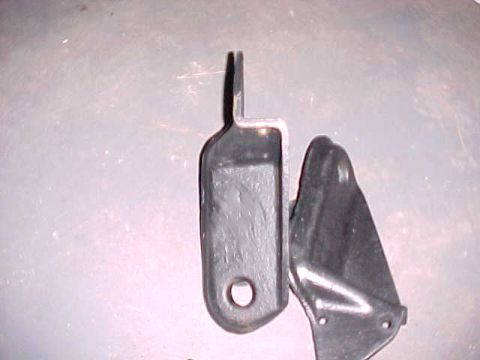 1995 Ford Bronco - Two metal brackets are shown, one with a circular hole and the other with a triangular shape.