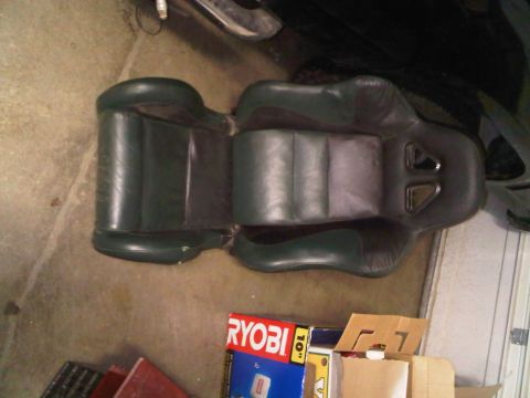 1985 Ford Bronco - These car seats are shown on a concrete floor with some boxes and garage items in the background.