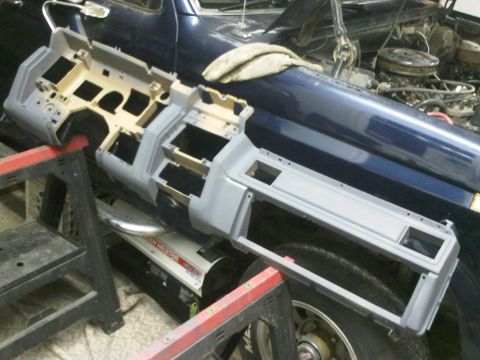 1985 Ford Bronco - Dashboard assembly removed from a vehicle, resting on sawhorses with the vehicle's interior and engine bay visible.