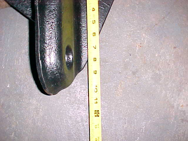Black metal bracket with yellow measuring tape showing inches from 4 to 14