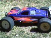 1985 Ford Bronco - A remote control monster truck with a flame graphic is seen from the side.