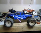 1985 Ford Bronco - Two remote control vehicles are displayed on a workbench.