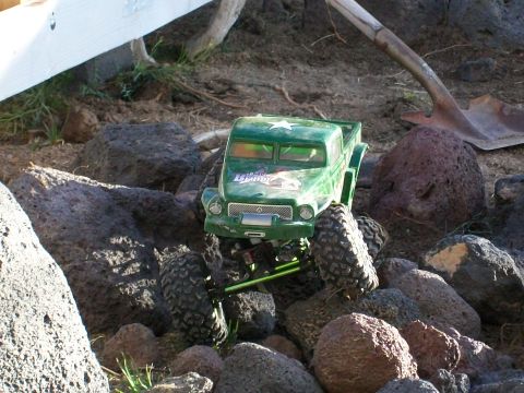 1985 Ford Bronco - Toy truck model is shown off-road amongst large rocks and dirt.