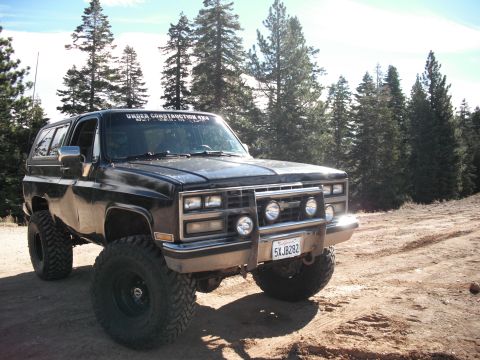 1991 Ford Bronco - This lifted 1985 Chevrolet K5 Blazer sits on a dirt road surrounded by pine trees.