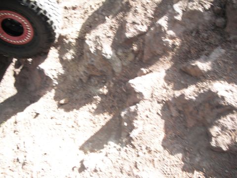 1991 Ford Bronco - A close-up view of a vehicle's tire and rim on a rough, rocky surface.