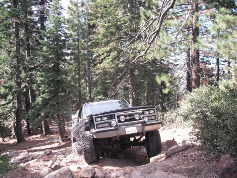 1991 Ford Bronco - This vehicle appears to be from the 1980s, not a 1991 Ford Bronco, as it navigates a challenging off-road path.