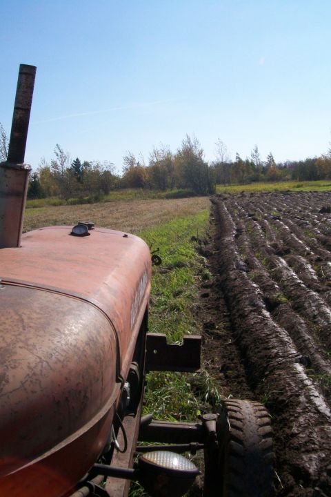 2000 Chevrolet Tahoe - A tractor is seen plowing a field on a sunny day.