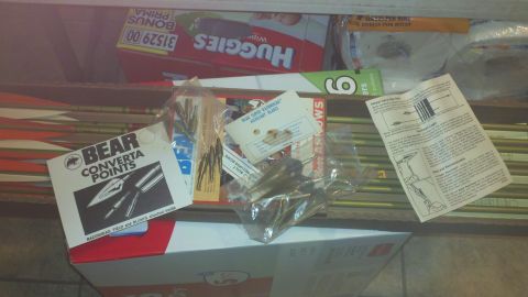 2010 Champion 188 - A collection of archery supplies, including arrows and various arrowheads, are organized in a box.