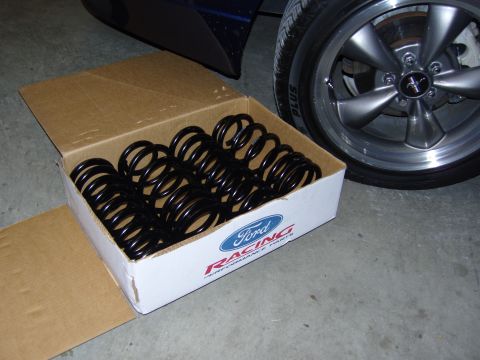 2007 Ford Mustang - A box of Ford Racing performance parts, containing suspension springs, sits beside a Mustang wheel.