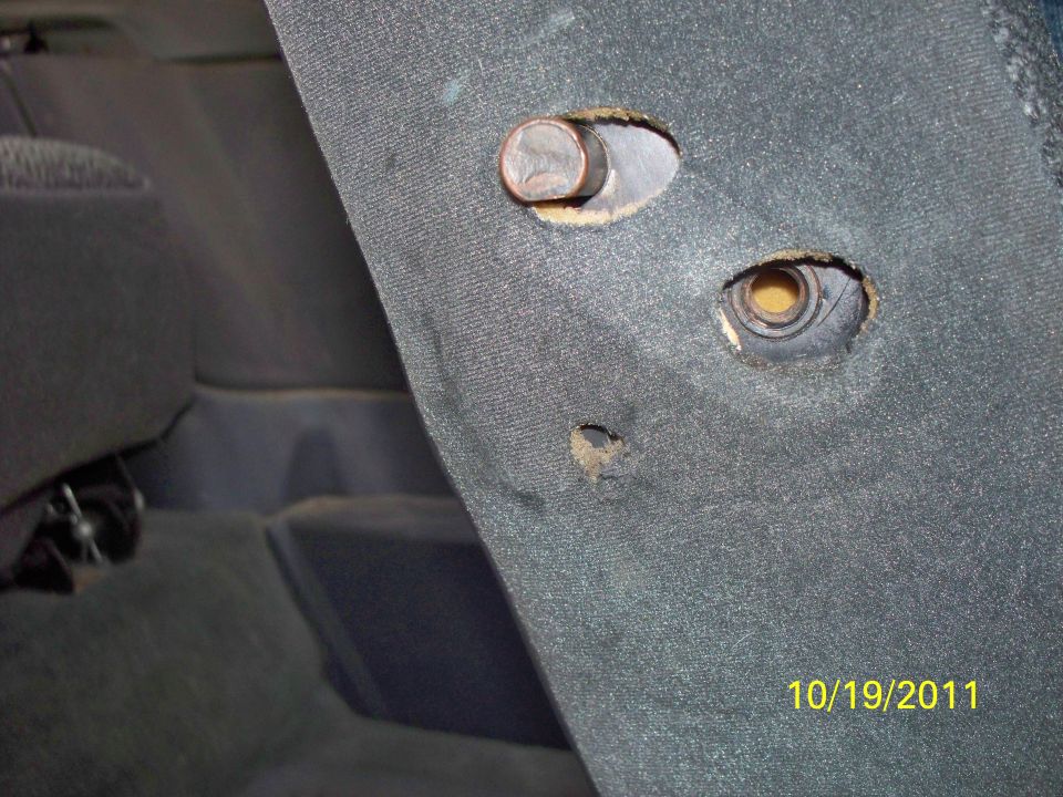 Close-up of carpeted interior trim panel with mounting holes