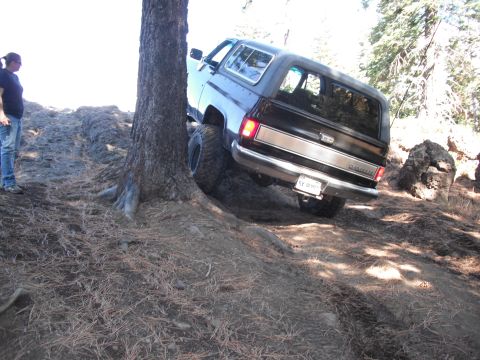 1991 Ford Bronco - A person watches as a Chevrolet K5 Blazer navigates a steep, wooded trail.