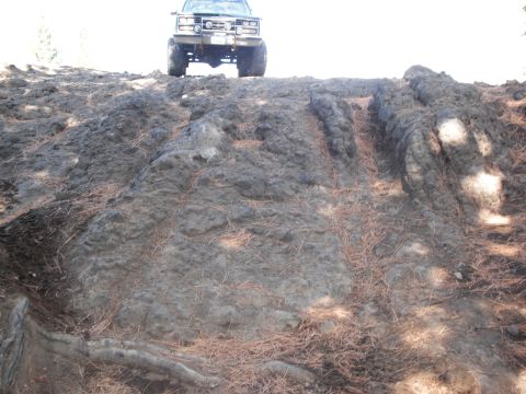 1991 Ford Bronco - A lifted pickup truck navigates a challenging rocky terrain.