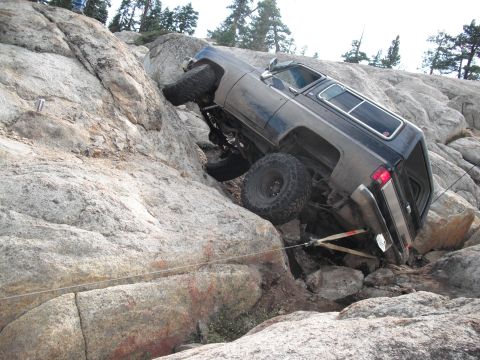 1991 Ford Bronco - An off-road SUV navigates a steep, rocky terrain, demonstrating its off-road capabilities.