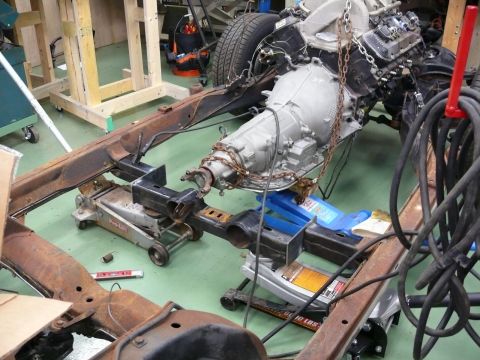1976 Chevrolet Corvette - The vehicle's frame, engine, and transmission are disassembled and supported by jacks in a workshop.