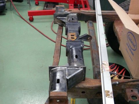 1976 Chevrolet Corvette - Close-up of vehicle frame components, possibly for restoration, with a ruler for scale and an Eastwood branded box in the background.