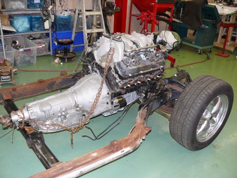 1976 Chevrolet Corvette - The engine and transmission are suspended above the vehicle's chassis, awaiting installation.