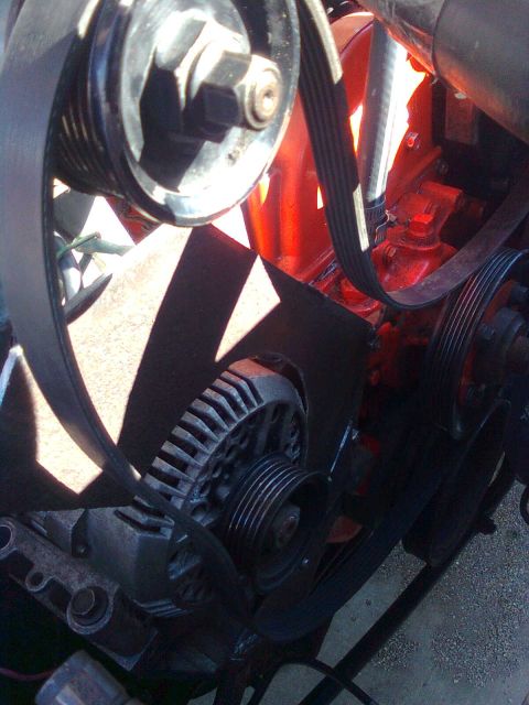 1984 Ford Bronco - Close-up view of the alternator and serpentine belt system within an engine bay.
