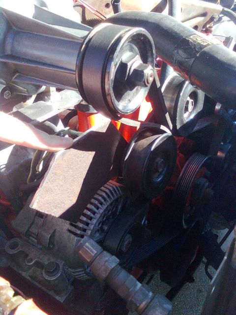 1984 Ford Bronco - Close-up of engine components, including a supercharger pulley and belt system.