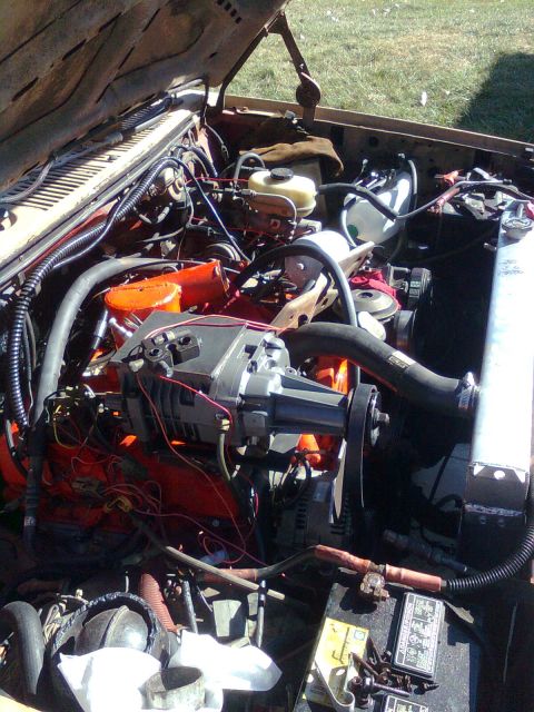1984 Ford Bronco - Close-up view of an engine bay a supercharger and various engine components.