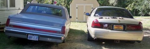 2000 Mercury Grand Marquis - Two sedans are parked in a grassy area next to a shed. The Mercury Grand Marquis is on the right.