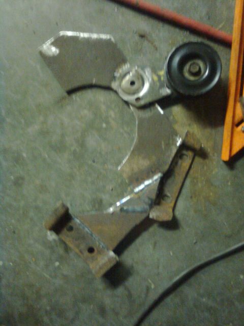 1984 Ford Bronco - Several broken metal components lie on the ground, suggesting a recent repair or damage.