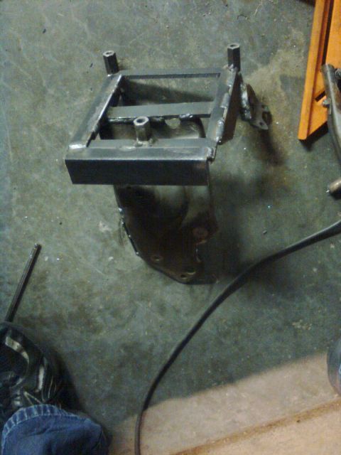 1984 Ford Bronco - A fabricated metal bracket, possibly for a vehicle modification, is shown on a concrete floor.