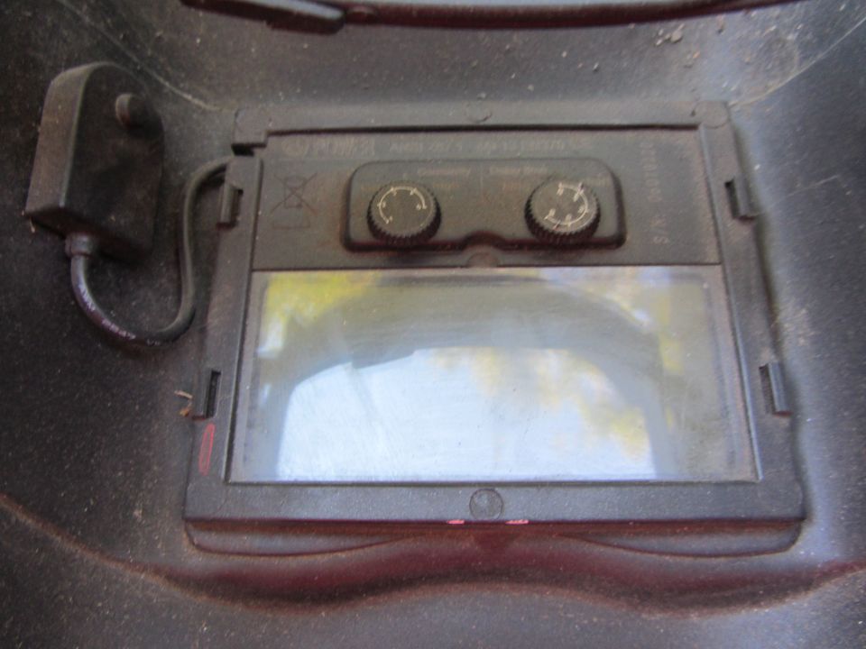 Welding helmet with two adjustment knobs and a dark viewing lens
