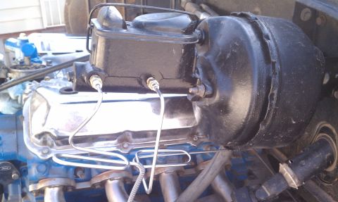 1979 Ford Bronco - Close-up view of the brake booster and master cylinder mounted on the engine.