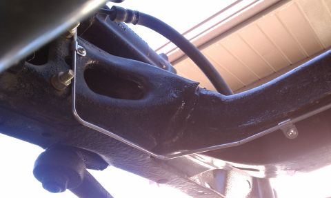1979 Ford Bronco - Underside view of a vehicle's brake line and suspension part.