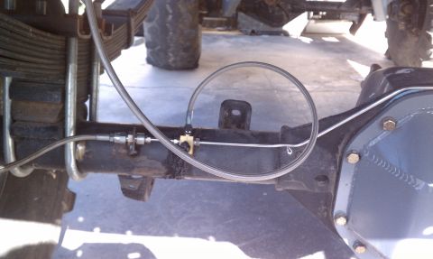 1979 Ford Bronco - Custom brake line setup on a rear axle, showing a proportioning valve and flexible hoses.