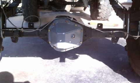 1979 Ford Bronco - Close-up of a vehicle's rear axle differential cover and brake lines, showing mechanical components.