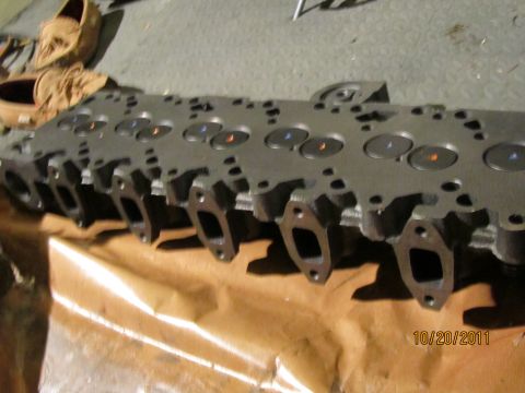 1984 Ford Bronco - A close-up view of an engine cylinder head, showing the intake and exhaust ports and valve stems.