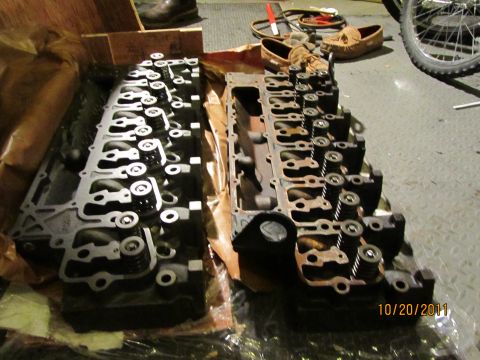 1984 Ford Bronco - Two engine cylinder heads are shown in a garage setting, with a date stamp indicating they were photographed in 2011.