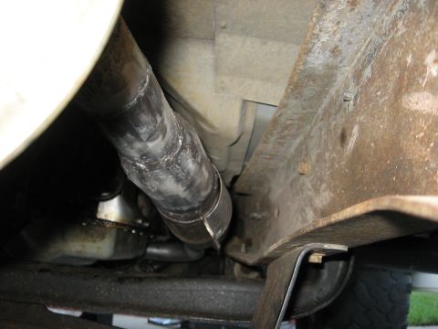 1994 Ford Bronco - Underside view of a vehicle's exhaust system and frame components.