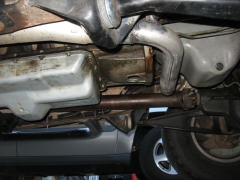 1994 Ford Bronco - Underside view of the exhaust and drivetrain of a 1994 Ford Bronco, showing the transmission pan and driveshaft.
