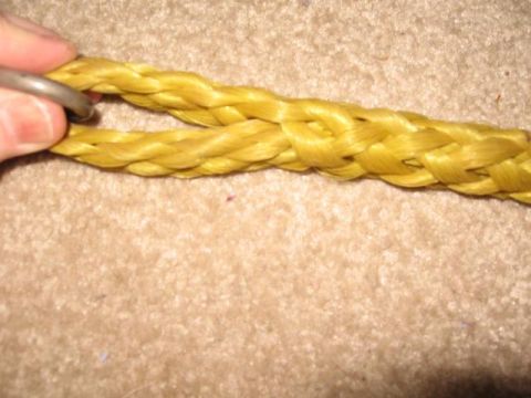 1978 Ford Bronco - A close-up view of a yellow rope with a metal ring, resting on a carpeted floor.