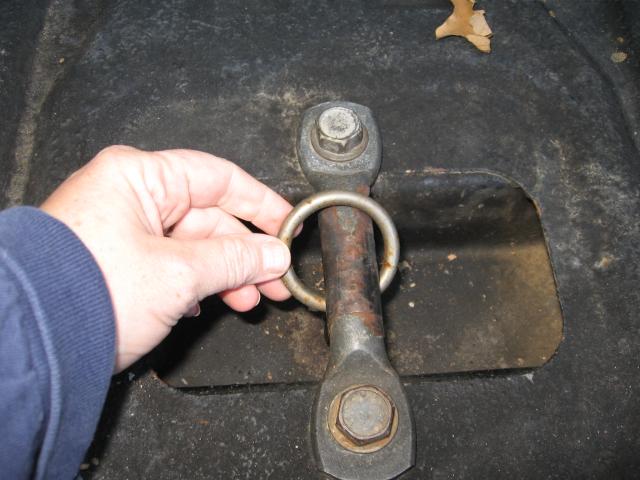 Hand holding a metal tie-down ring attached to a bolt assembly