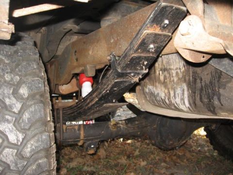 1978 Ford Bronco - Underside view of a vehicle's suspension system, focusing on the leaf springs and shock absorber.