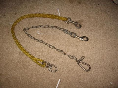 1978 Ford Bronco - A yellow rope leash and a metal chain with clips are laid out on a carpeted surface.