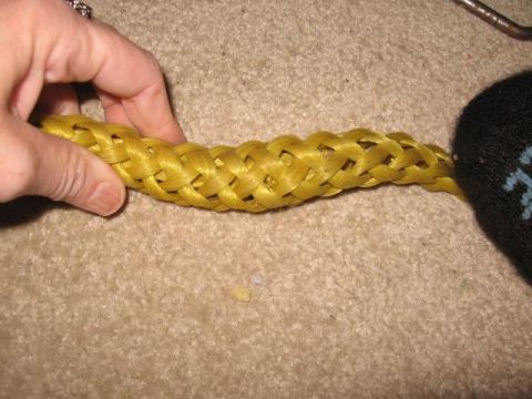 1978 Ford Bronco - A yellow tow rope is shown being held by a hand, with a black sock on the other end.