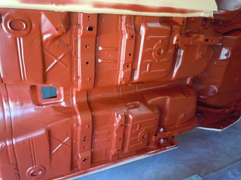 1973 Pontiac Trans Am - The underside of a vehicle is coated in red primer, revealing structural details.